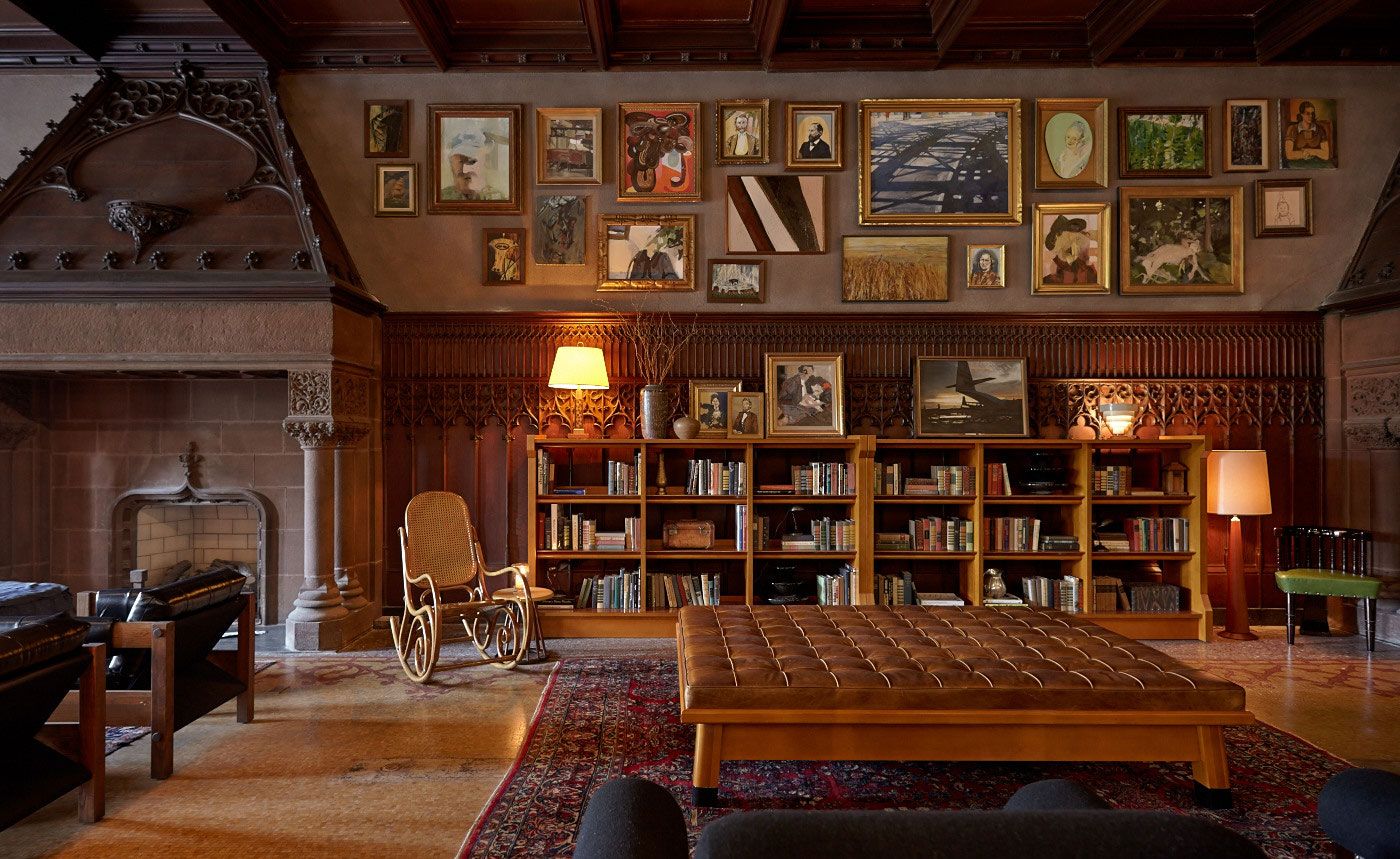 Image may contain furniture, chairs, bookcases, home decor, rugs, people art, paintings, lamps, interiors and interior design