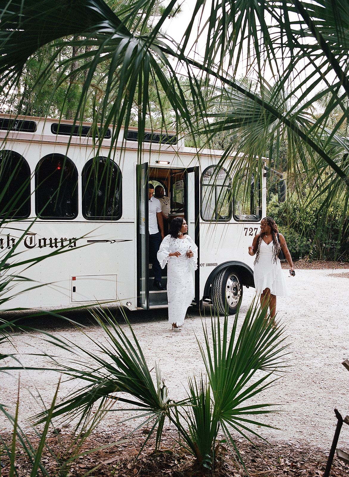 Image may contain adults, wedding figures, clothing, apparel, buses, transportation vehicle accessories and bags