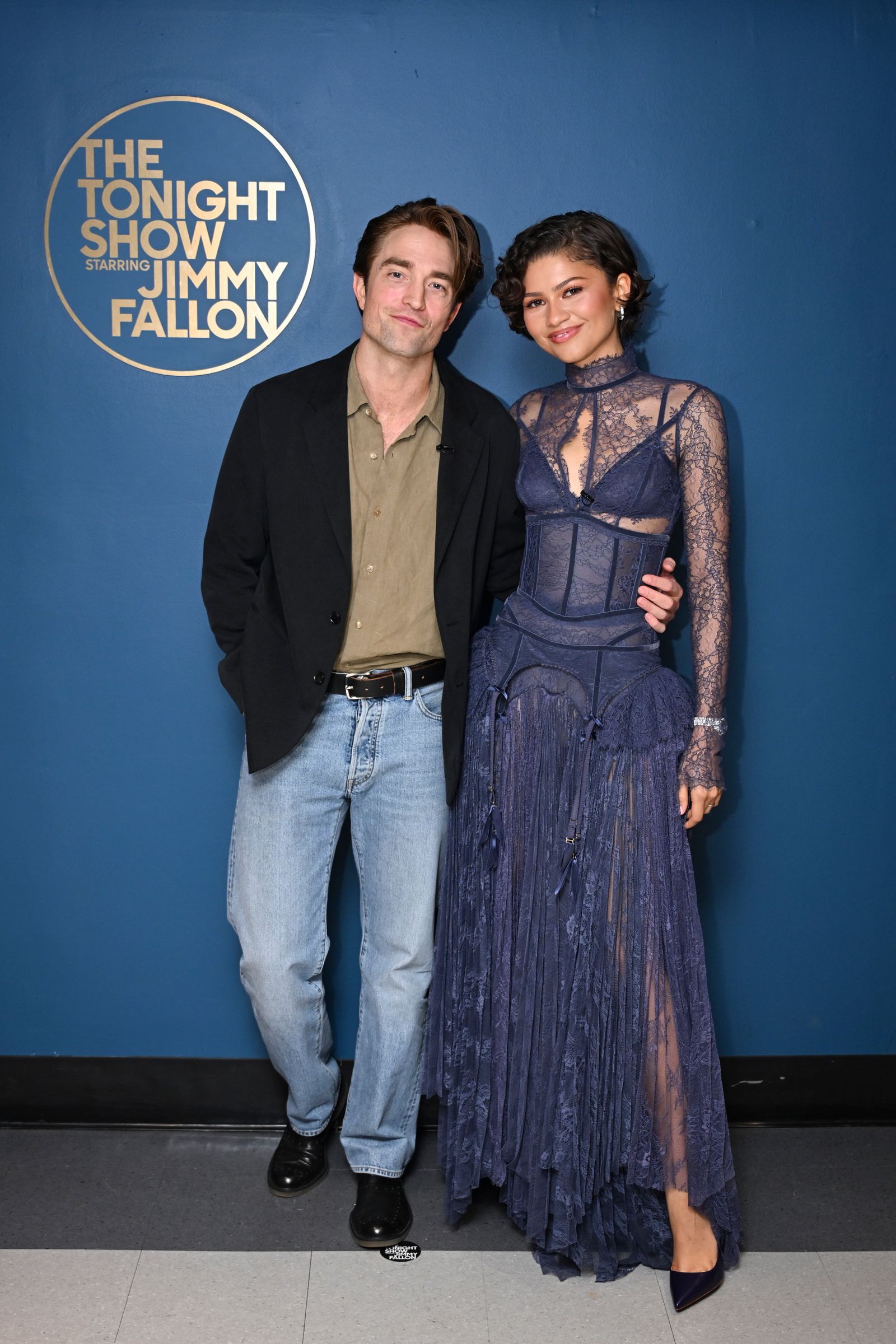 Image may contain Robert Pattinson Zendaya clothing pants fashion outerwear jackets adult blazers jeans and dresses