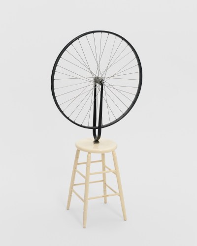 Bicycle wheel attached to wooden bench.