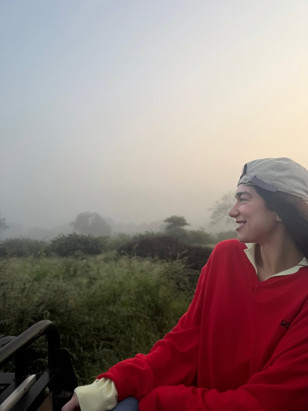 Image may contain Dua Lipa face Happy Head person smile plant vegetation adult photography portrait and grass