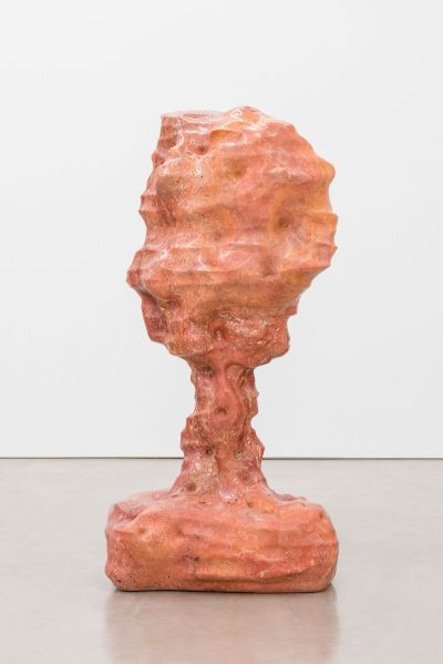 A pink sculpture that resembles an abstract head attached to a base.