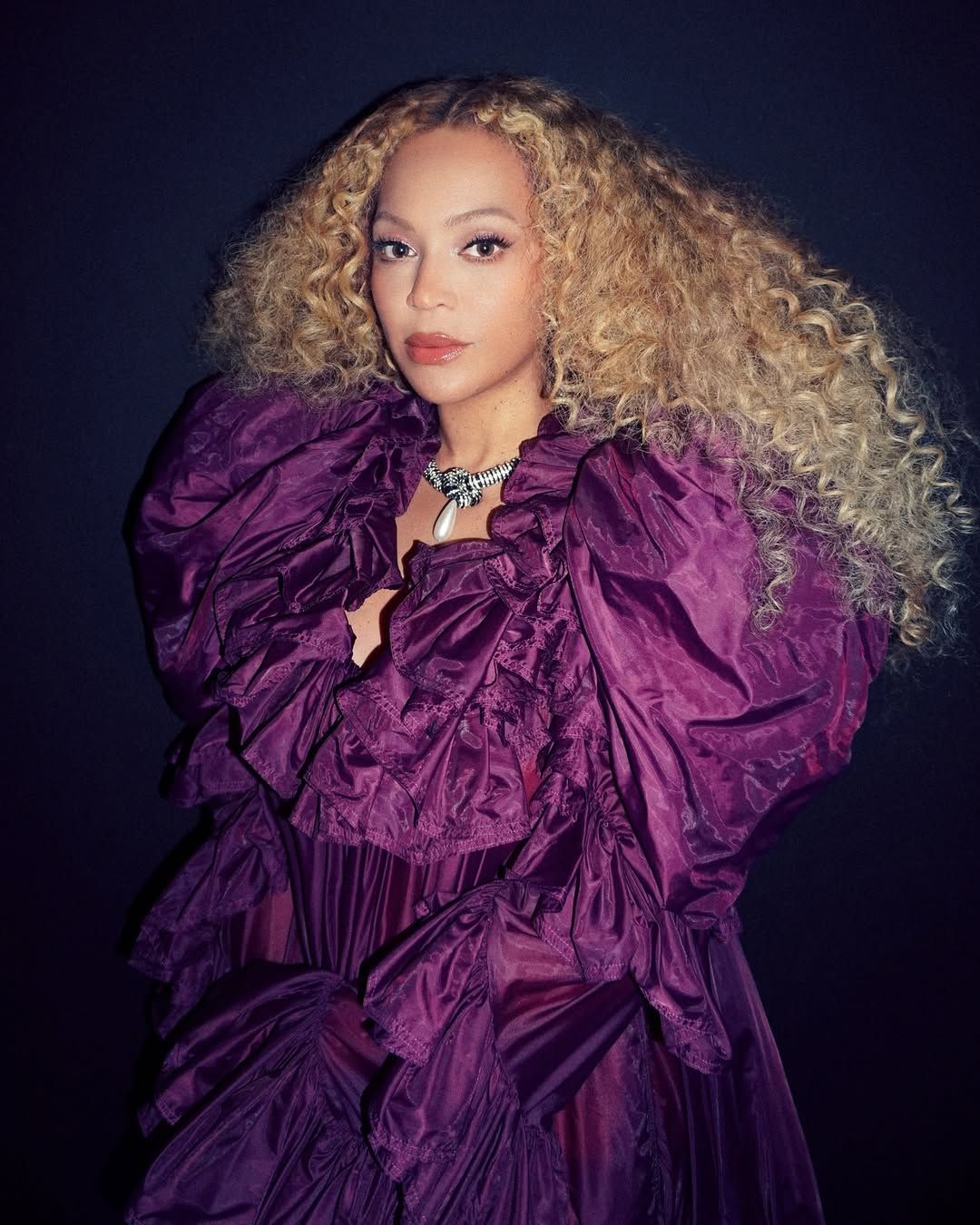 Image may contain Beyonc Purple adult clothing, dresses, blonde hair, face, head photography and portraits