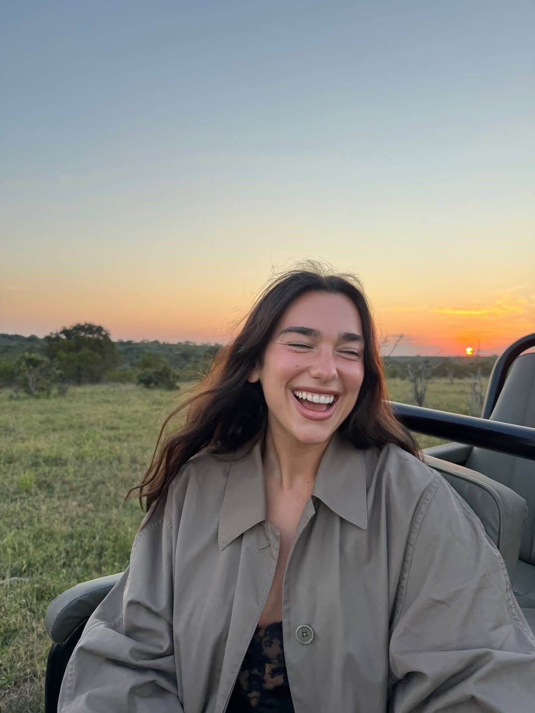 Image may contain Dua Lipa face avatar Happy Laughing Adult Smile clothing and outerwear