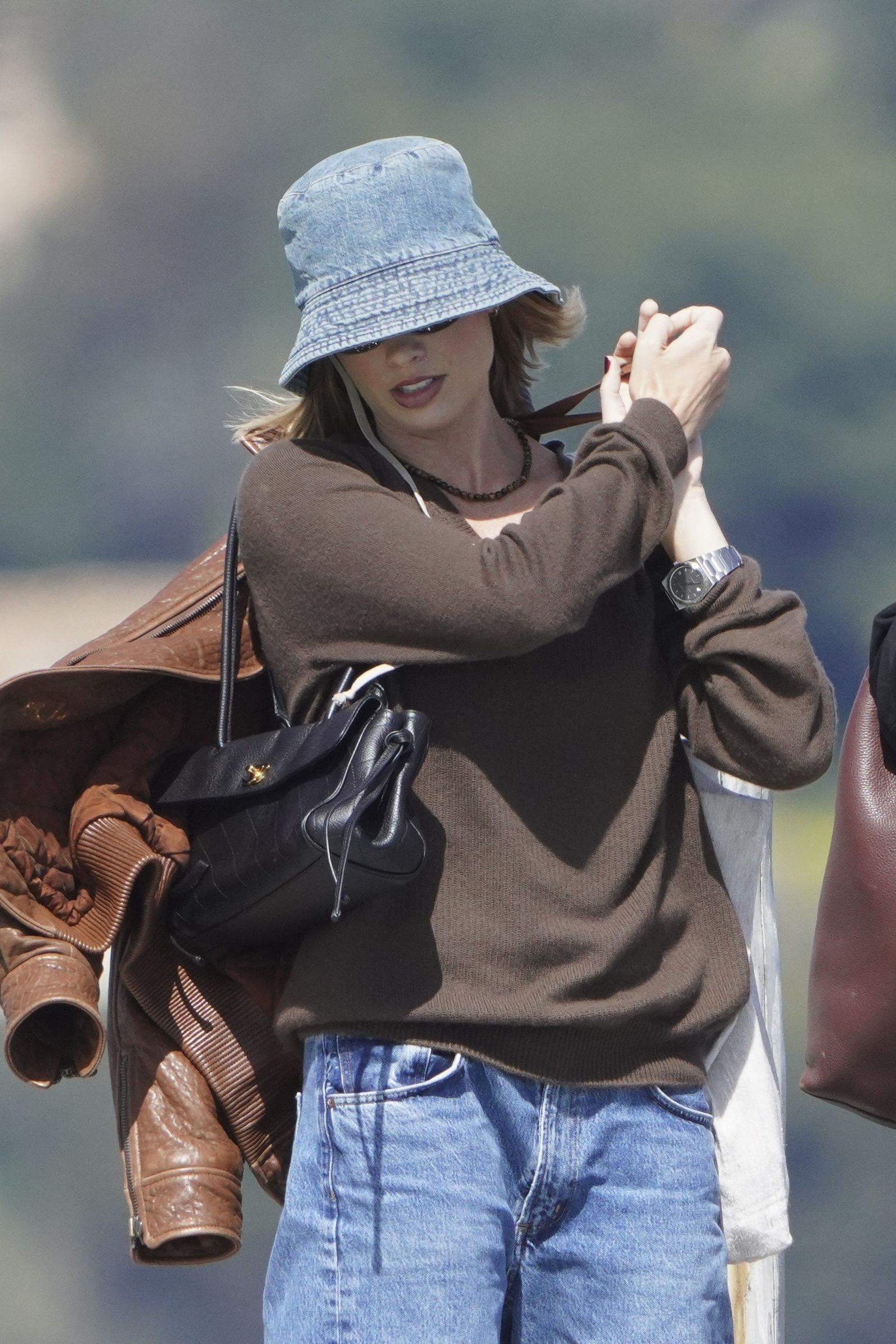 Image may contain E40 clothing, hats, accessories, bags, handbags, coats, jackets, pants, hats, jewelry, necklaces and adults