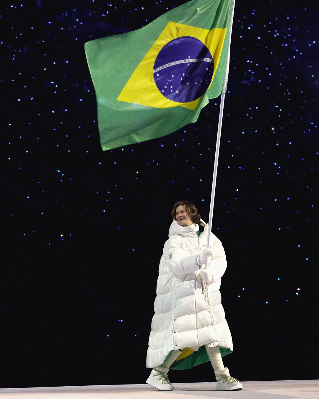 Image may contain flag, adult clothing, gloves, Brazilian flag, footwear and shoes