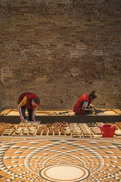 Two workers are installing mosaics.