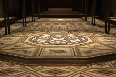 The floor is covered with mosaics depicting birds and abstract patterns.