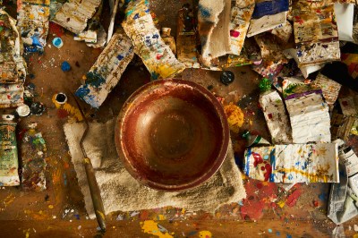 Surrounding the bowl is a set of used paint tubes.