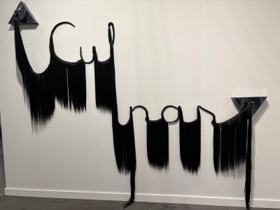 A sculpture made of synthetic hair arranged to spell out the word