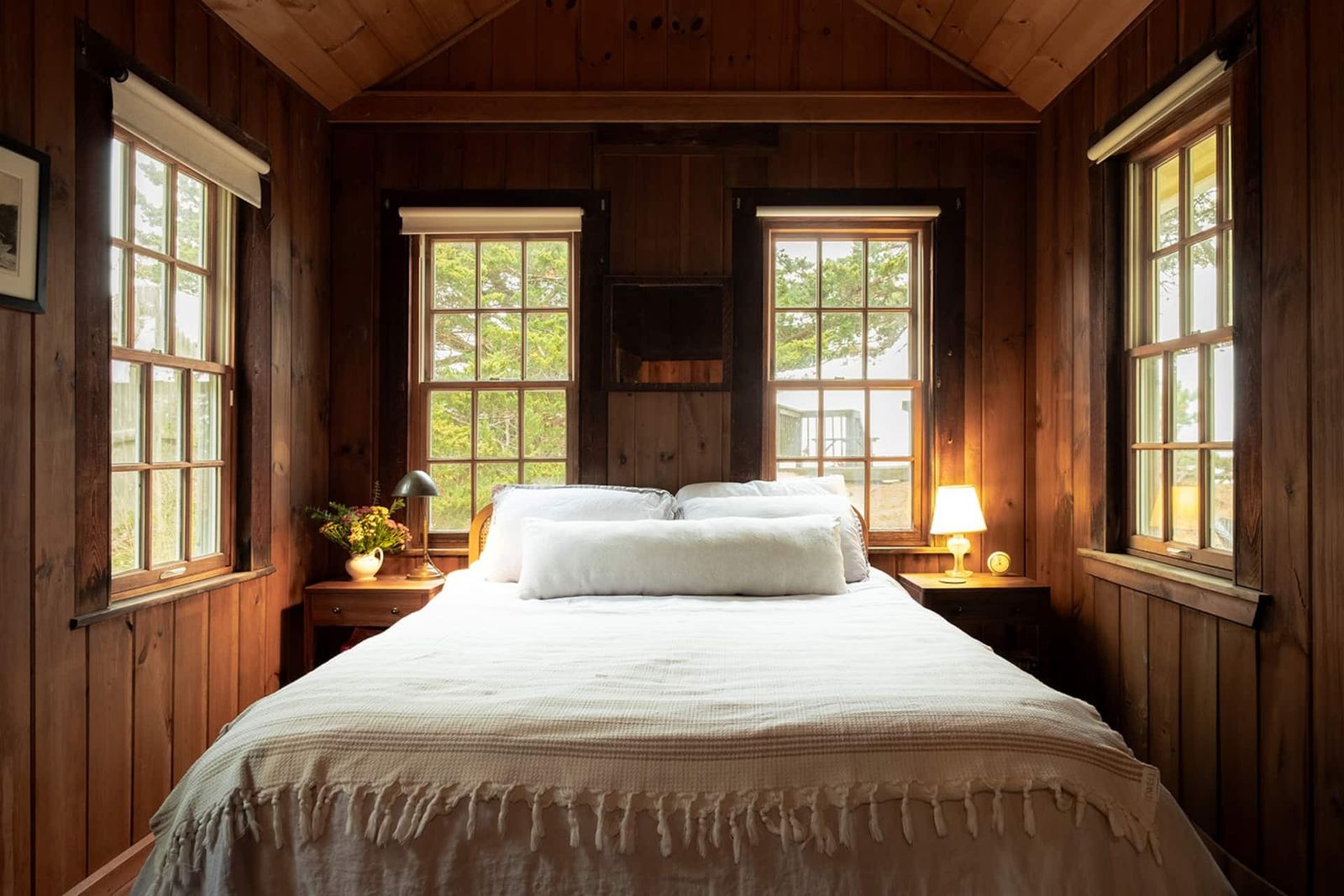 Image may contain interior interior design, hardwood, stained wood, wood bed, furniture, lamp, home decor and windows