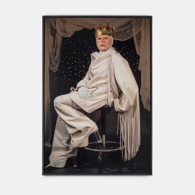 A picture of a woman wearing a white robe and a paper crown.