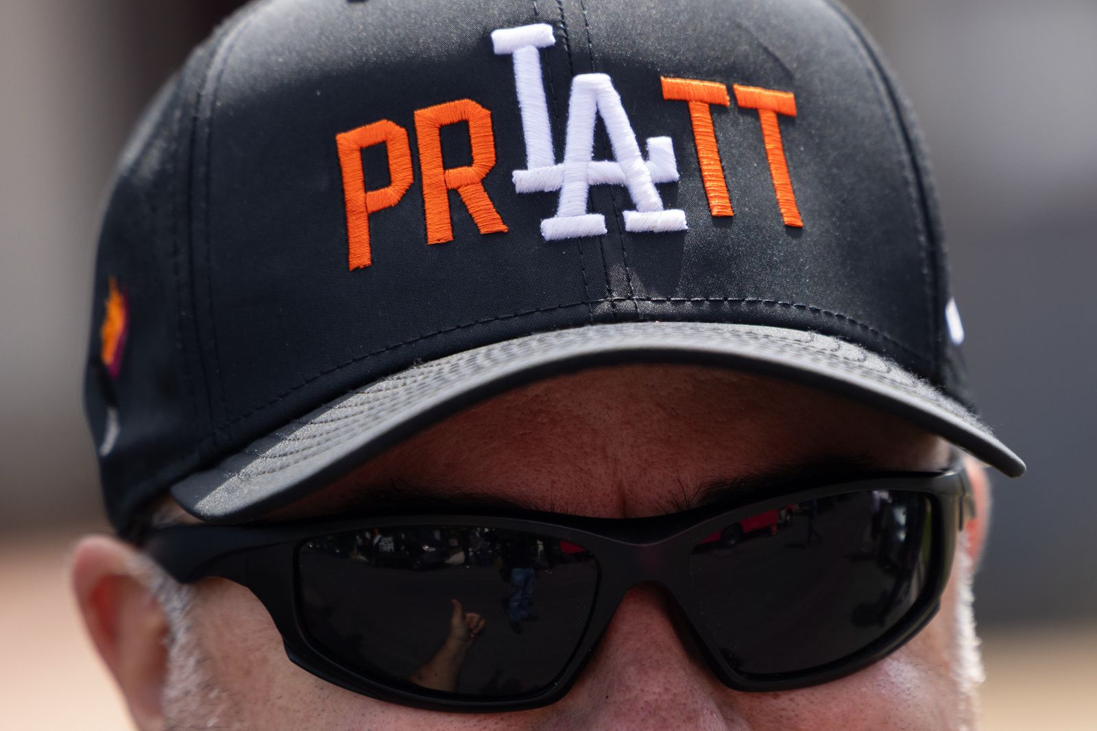 Image may contain baseball caps, hats, clothing, hat accessories, sunglasses, eyeglasses, adults, machines and wheels